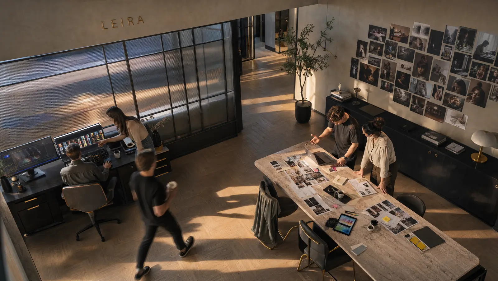 The Leira studio: the team reviewing printed frames around a work table